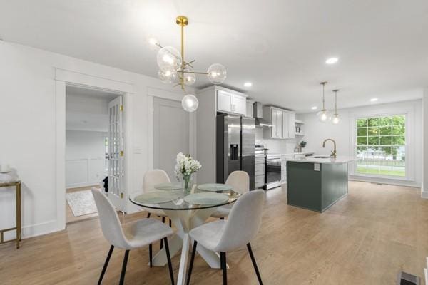 dining area with recessed lighting, a notable chandelier, and light wood-style flooring