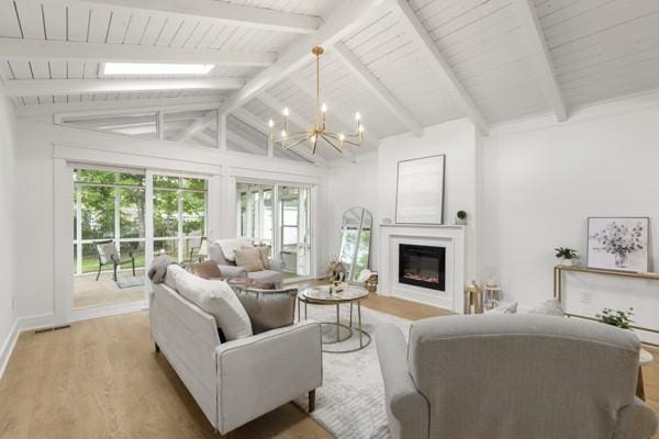 living room with wood ceiling, lofted ceiling with beams, a glass covered fireplace, a notable chandelier, and light wood-style floors