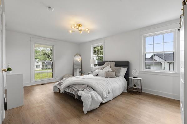 bedroom with light wood-style floors, baseboards, and a chandelier