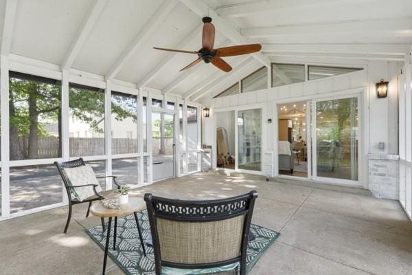 sunroom / solarium featuring beamed ceiling and a ceiling fan