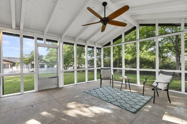 unfurnished sunroom featuring a ceiling fan and beamed ceiling