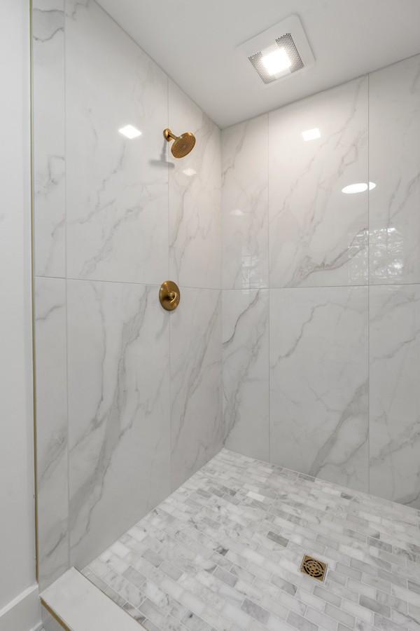 bathroom with visible vents and a marble finish shower