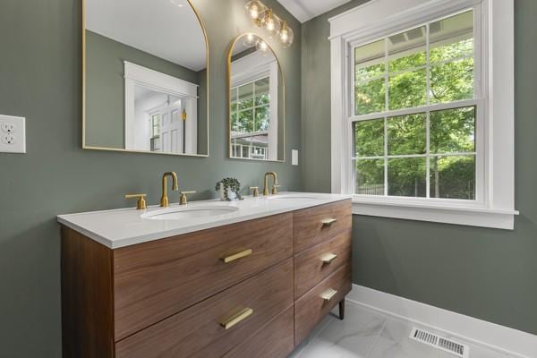 bathroom with visible vents, a wealth of natural light, and a sink