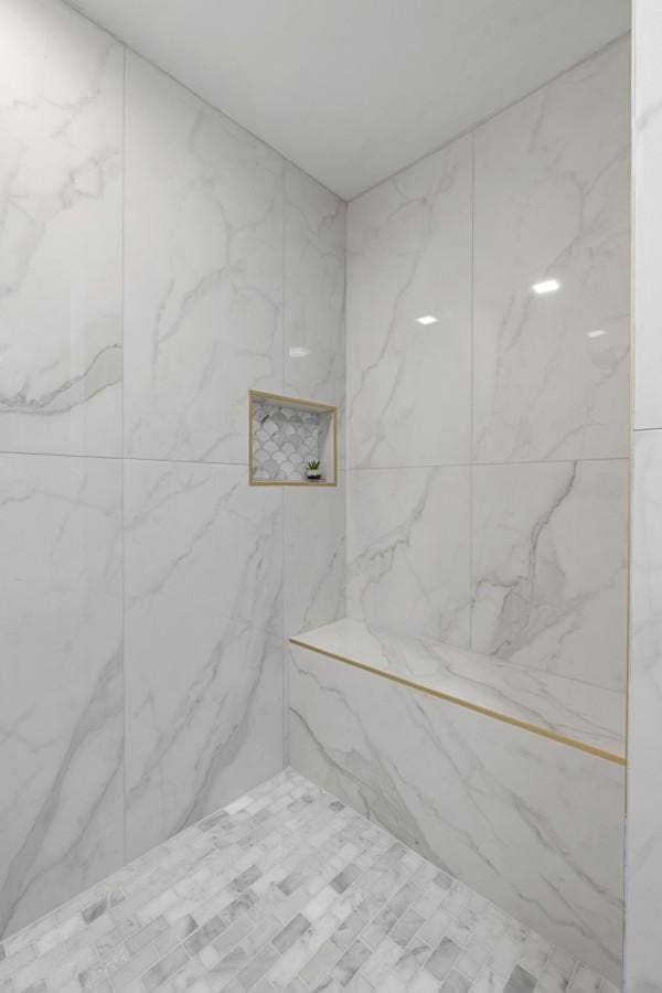 bathroom with a marble finish shower