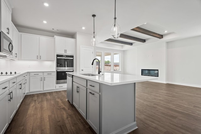 kitchen with backsplash, appliances with stainless steel finishes, dark wood finished floors, a sink, and recessed lighting