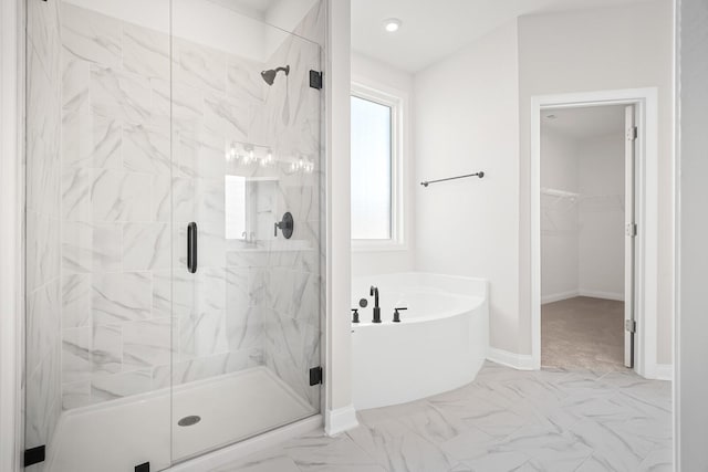 full bathroom with marble finish floor, baseboards, a shower stall, a spacious closet, and a garden tub
