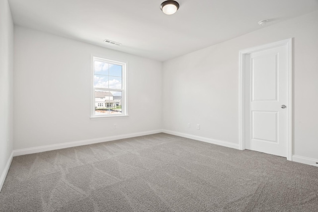 carpeted spare room with baseboards and visible vents