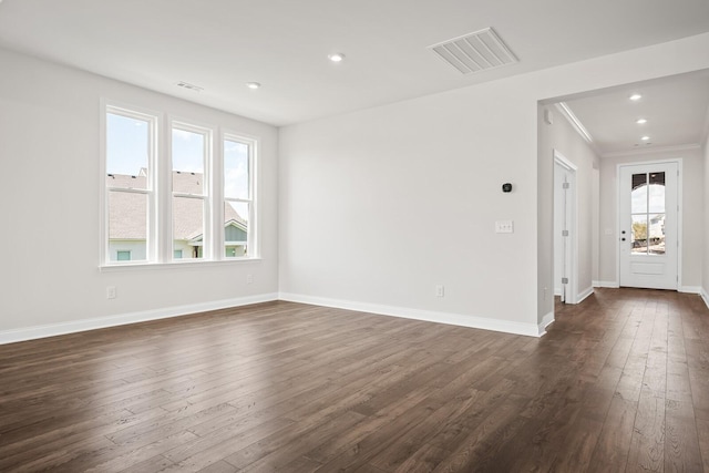 unfurnished room with recessed lighting, baseboards, dark wood-style flooring, and visible vents