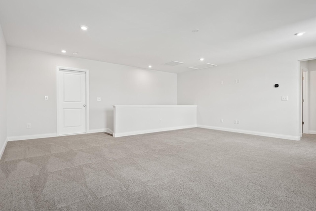 spare room with baseboards, light carpet, and recessed lighting