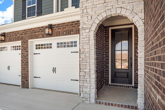 property entrance with brick siding and a garage
