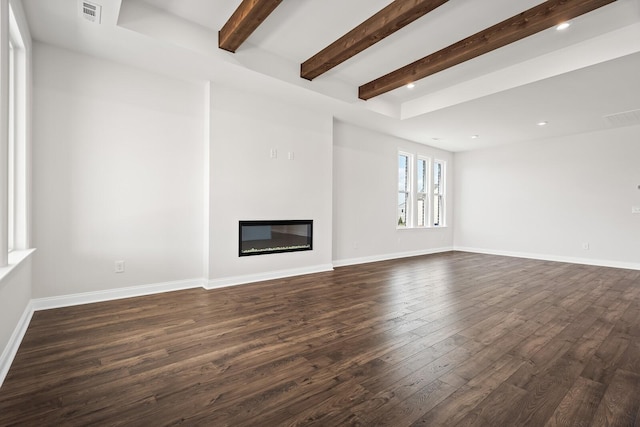 unfurnished living room featuring a glass covered fireplace, beamed ceiling, dark wood-style flooring, and visible vents