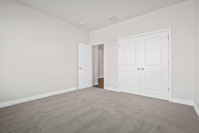 unfurnished bedroom with carpet floors, baseboards, a closet, and visible vents