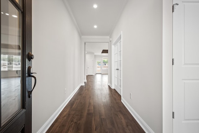 corridor with crown molding, dark wood-style flooring, baseboards, recessed lighting, and french doors