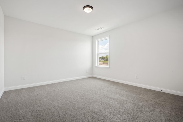 spare room featuring baseboards, carpet flooring, and visible vents