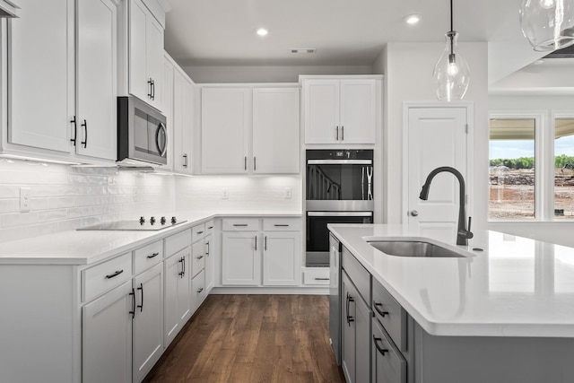 kitchen featuring light countertops, stainless steel appliances, recessed lighting, and a sink