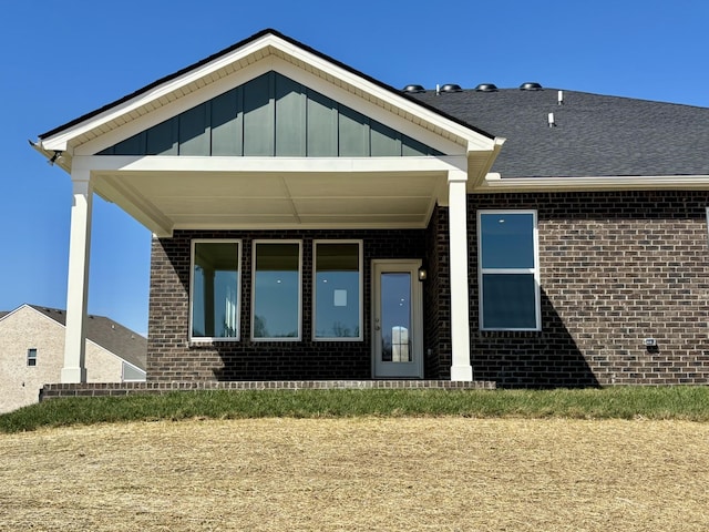 rear view of house with brick siding and board and batten siding