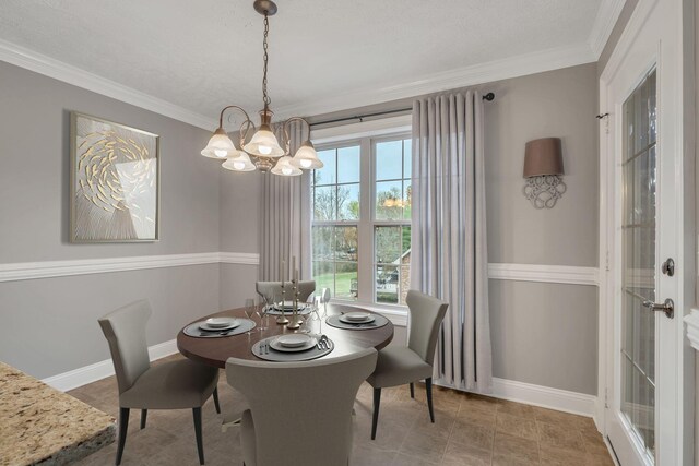 dining room featuring baseboards, a notable chandelier, and ornamental molding