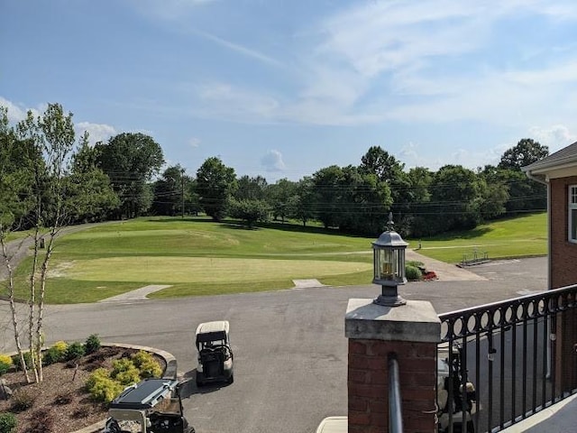 view of home's community with view of golf course and a yard