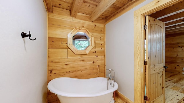 bathroom featuring wood ceiling, a freestanding tub, wood walls, wood finished floors, and beamed ceiling