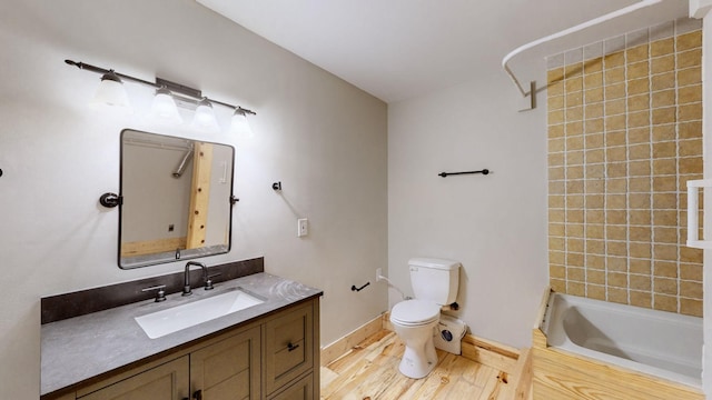 full bath with wood finished floors, shower / washtub combination, vanity, baseboards, and toilet