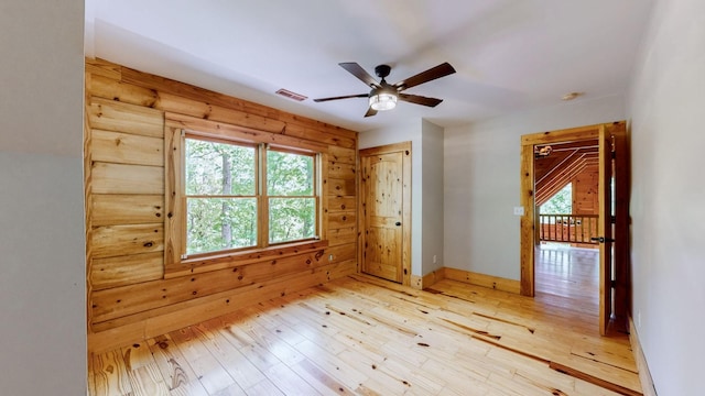 empty room featuring visible vents, light wood-style flooring, ceiling fan, and baseboards