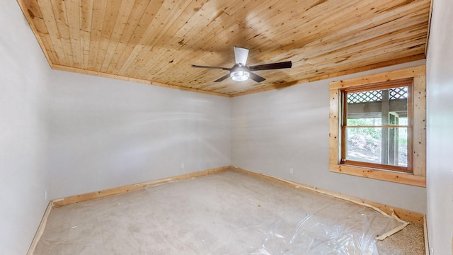 empty room featuring baseboards, ceiling fan, and wooden ceiling