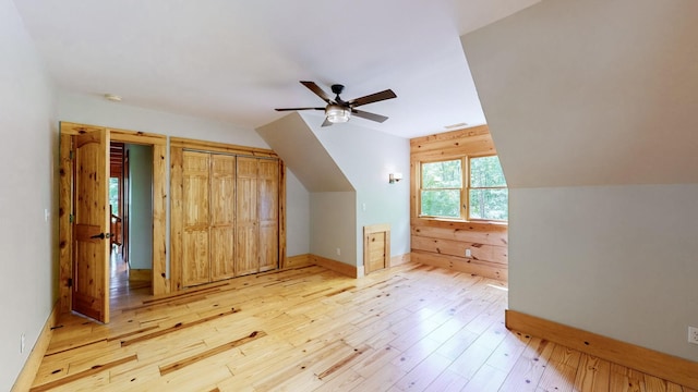 additional living space featuring ceiling fan, visible vents, baseboards, lofted ceiling, and light wood-style floors