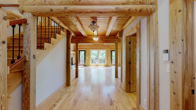 hallway featuring light wood finished floors, stairs, wood ceiling, beamed ceiling, and log walls