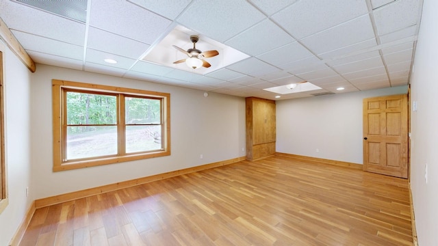empty room with light wood-style floors, a paneled ceiling, recessed lighting, baseboards, and a ceiling fan