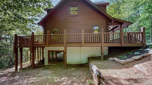 back of house with log siding and a wooden deck