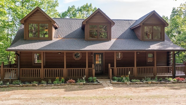 back of house with a porch, a shingled roof, and log exterior