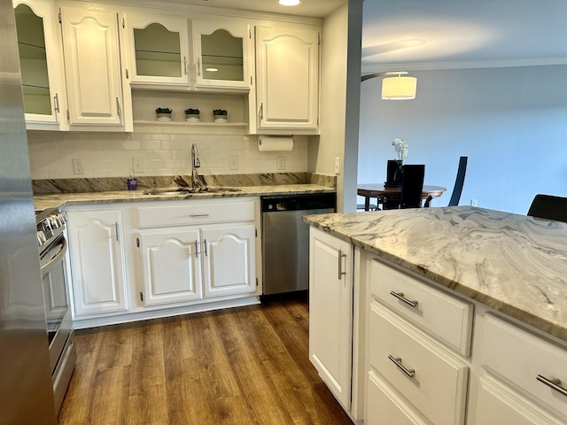 kitchen featuring appliances with stainless steel finishes, tasteful backsplash, light stone countertops, a sink, and dark wood-style floors