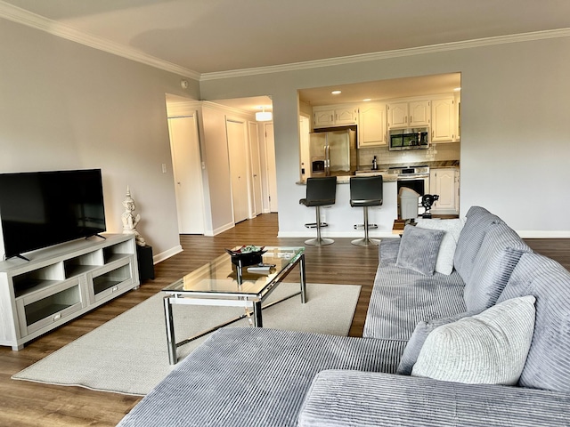 living room featuring baseboards, ornamental molding, and dark wood finished floors