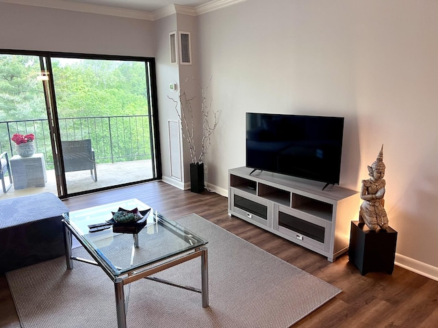 living area with crown molding, baseboards, visible vents, and wood finished floors