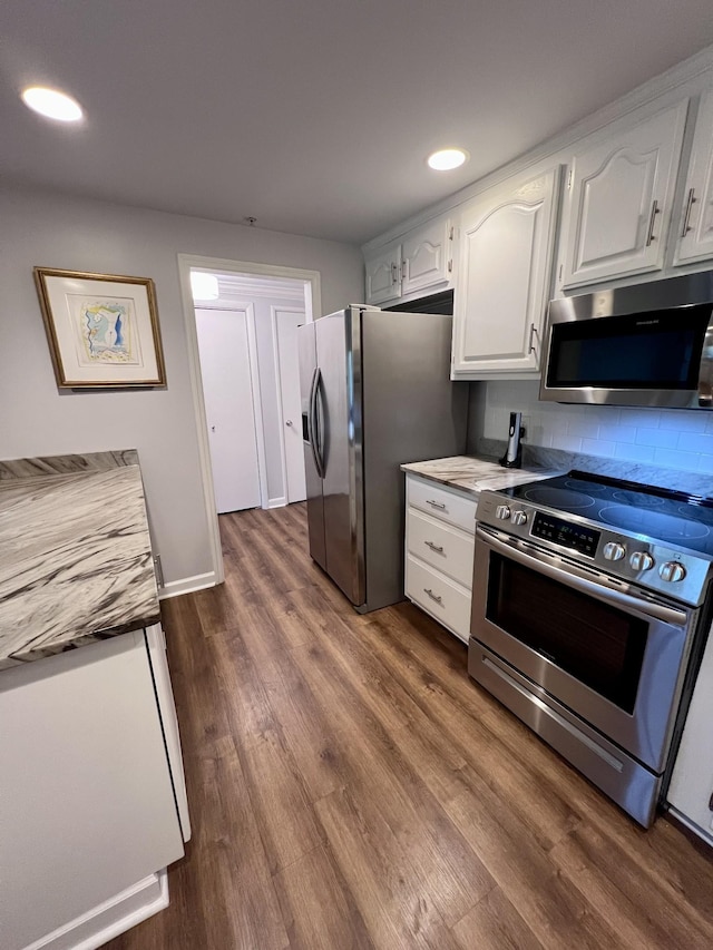 kitchen featuring backsplash, appliances with stainless steel finishes, dark wood-style floors, recessed lighting, and white cabinetry