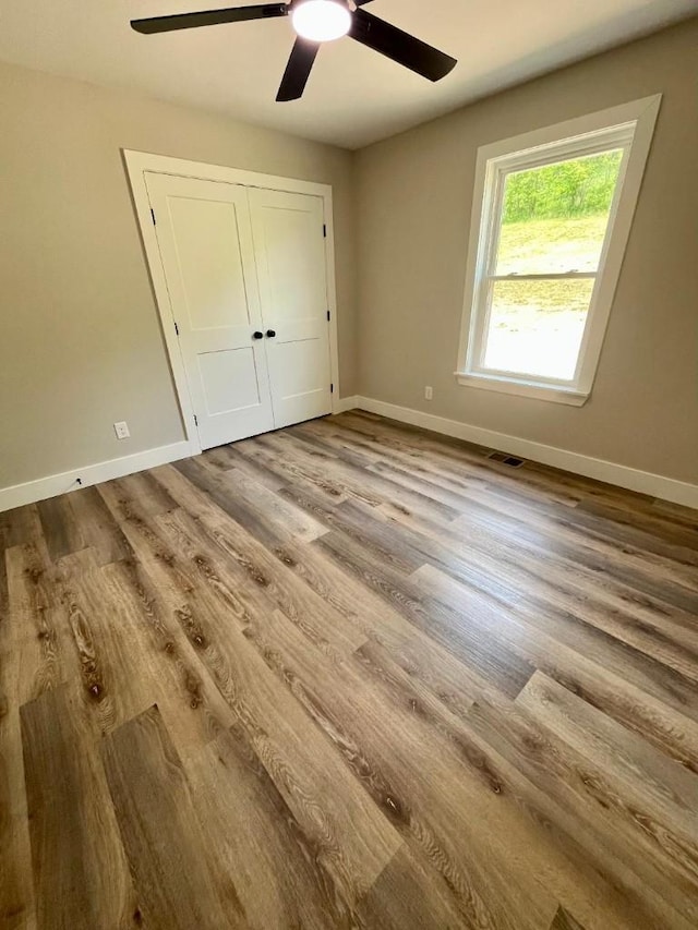 unfurnished bedroom with baseboards, visible vents, and wood finished floors