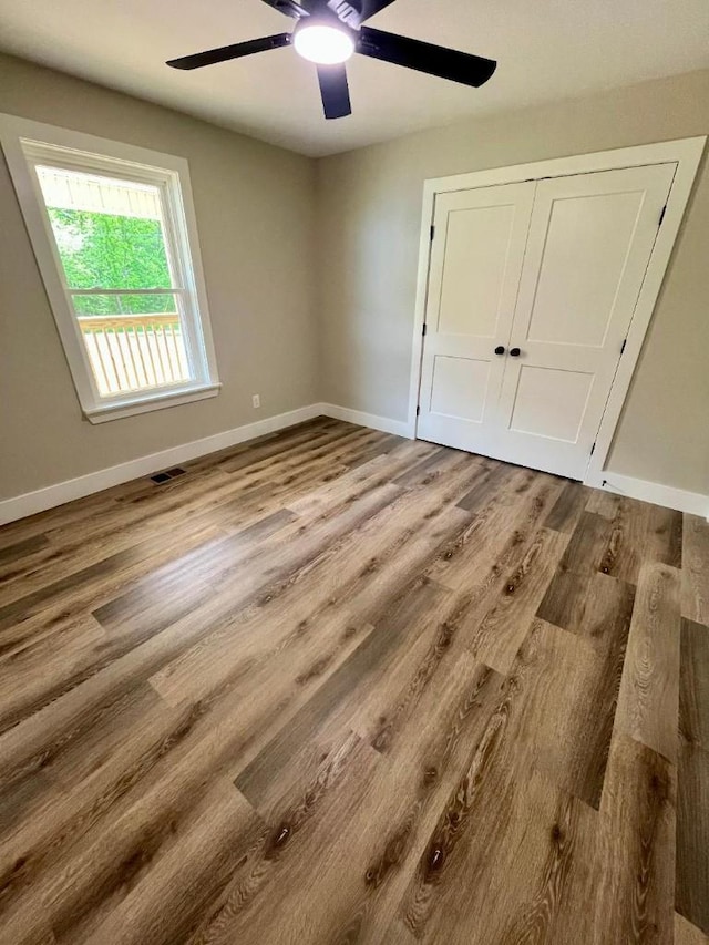 unfurnished bedroom featuring baseboards, ceiling fan, and wood finished floors