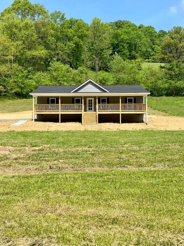 view of front of home featuring crawl space, a forest view, and a front lawn