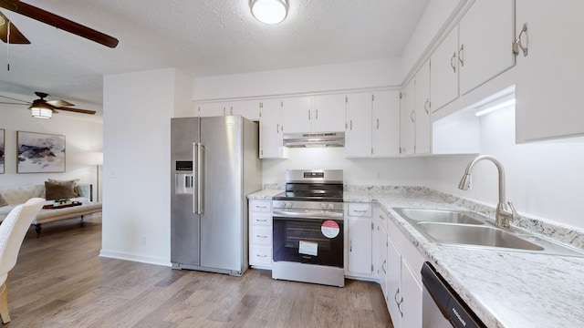 kitchen with ceiling fan, appliances with stainless steel finishes, a sink, light wood-style floors, and under cabinet range hood