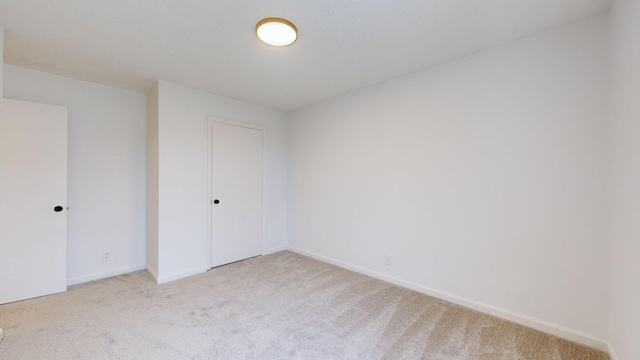unfurnished bedroom featuring carpet floors and baseboards