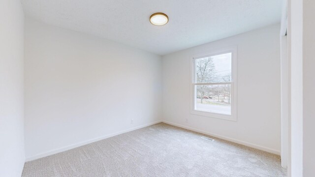 spare room with baseboards and carpet