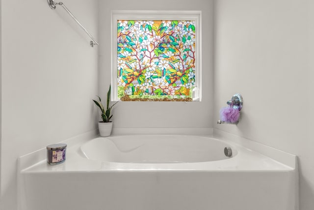 full bathroom featuring a healthy amount of sunlight and a bath