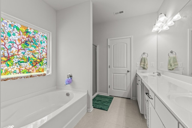 bathroom featuring double vanity, a bath, visible vents, tile patterned flooring, and a sink
