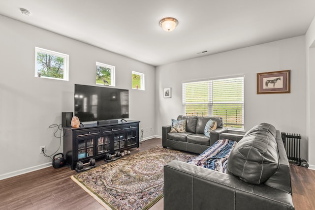 living area featuring dark wood-style flooring, baseboards, and visible vents