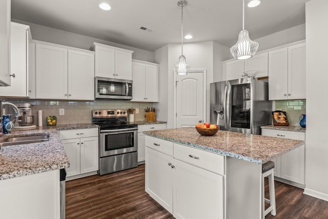 kitchen with a sink, dark wood finished floors, stainless steel appliances, recessed lighting, and tasteful backsplash