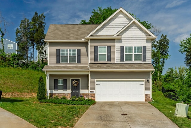 craftsman-style house with concrete driveway, stone siding, a front yard, and a garage