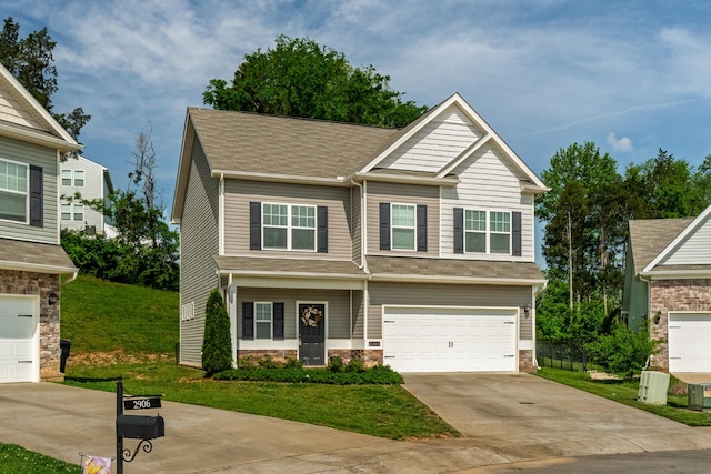 craftsman-style home featuring a garage, a front lawn, concrete driveway, a shingled roof, and stone siding