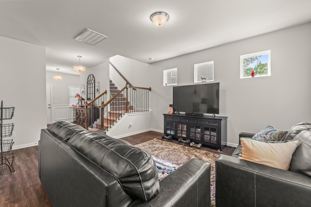 living room featuring stairs, baseboards, visible vents, and dark wood-style floors