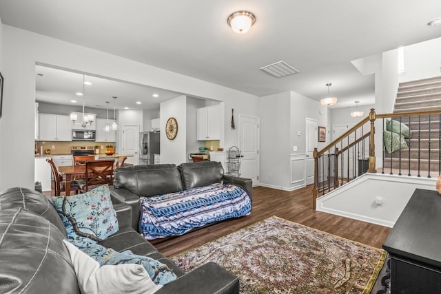living room featuring visible vents, stairs, baseboards, recessed lighting, and dark wood finished floors
