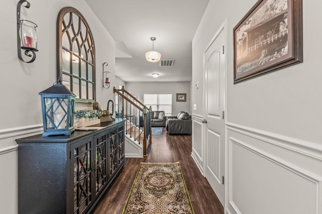 hallway with wainscoting, dark wood-type flooring, stairs, and visible vents